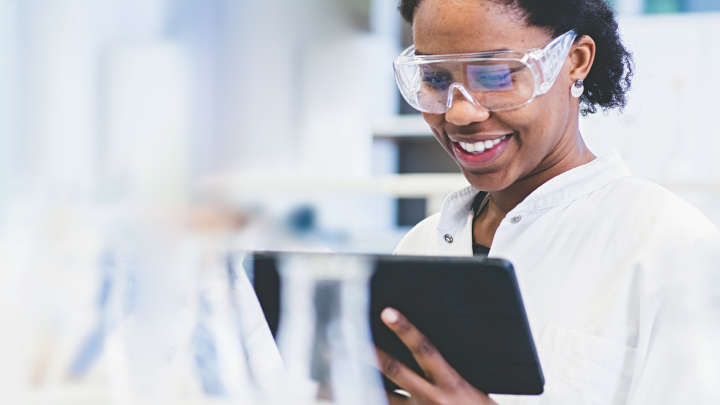 Scientist with tablet and protective glasses